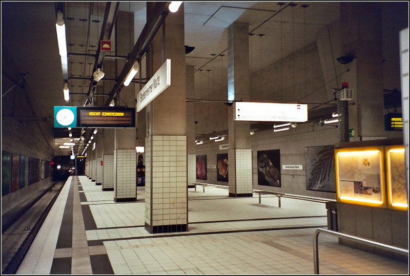 Bockenheimer Warte, Linie U4 (B-(D-)Strecke). Die hohe Bahnsteighalle wird durch die doppelte Sttzenreiche geprgt. An nrdlichen Bahnsteigende besteht ein bergang zur C-Strecke mit den Linien U6 und U7, die eine Etage hher abfahren. Zwischen beiden Strecken gibt es zudem eine Gleisverbindung. Eigentlich sollte der Tunnel bis nach Ginnheim weitergebaut werden. Dort sollte Anschluss an den bestehenden Abzweig der A-Strecke geschaffen werden und die U4 bis Nieder-Eschbach verlngert werden, wobei im Bereich Riederberg die dortige Neubaustrecke befahren werden sollte. 09.2003 (Matthias)