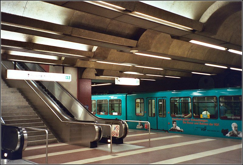 Kirchplatz, Linien U6, U7 (C-Strecke). Der erste Abschnitt (Rampe Industriehof - Zoo) der dritten Stammstrecke ging am 11. Oktober 1986 in Betrieb. Die Station Kirchplatz ist die letzte unterirdische Station im Westen der Strecke. Nach Ausfahrt aus dem Tunnel fahren die Bahnen oberirdisch weiter nach Hausen (U7) und zur Heerstrae (U6). Scan, 09.2003 (Matthias)